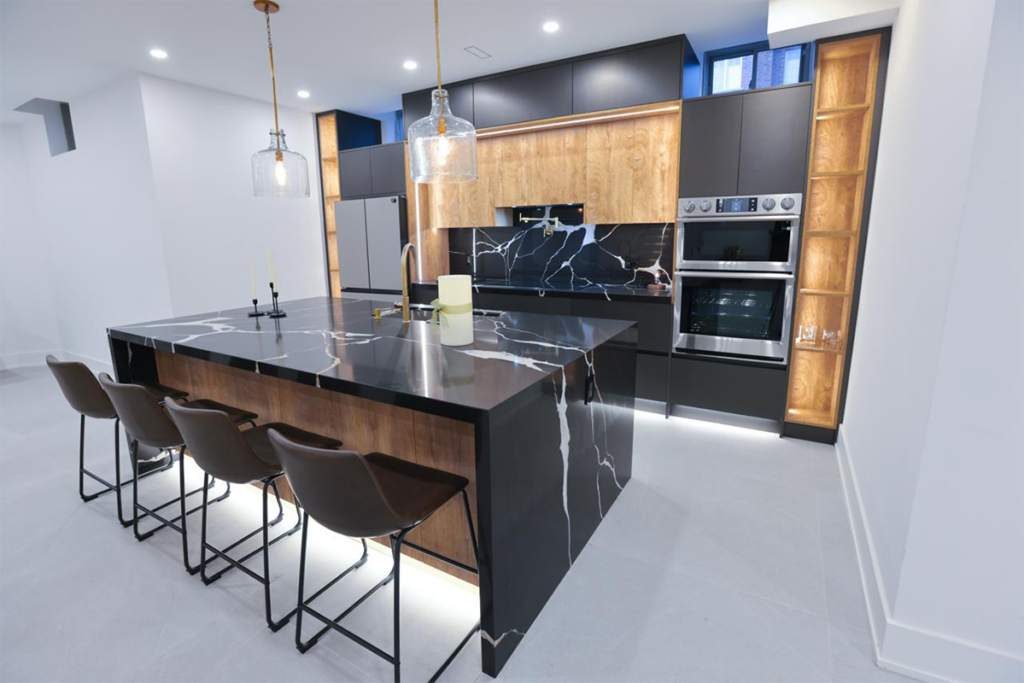 Legal Basement Apartment in Toronto: Requirements, Permits & Cost (2026) 3 Basement apartment kitchen with black quartz waterfall island and wood cabinetry by Route Homes