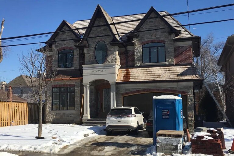 Stone and brick house by Route Homes near completion at the Tamworth residence, with windows in and roofing done